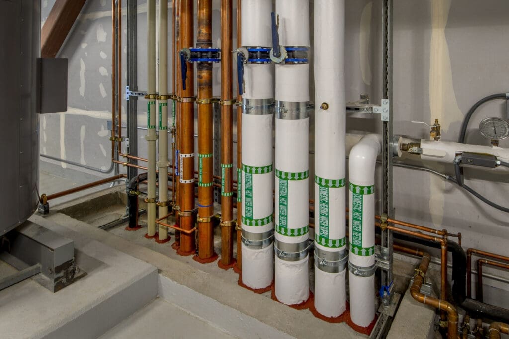 Boiler room with insulated pipes and fire stops.